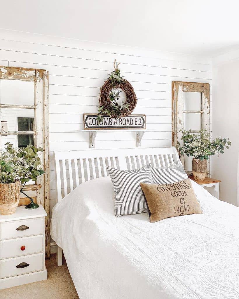 white shiplap wall farmhouse bedroom with dual wall mirrors 