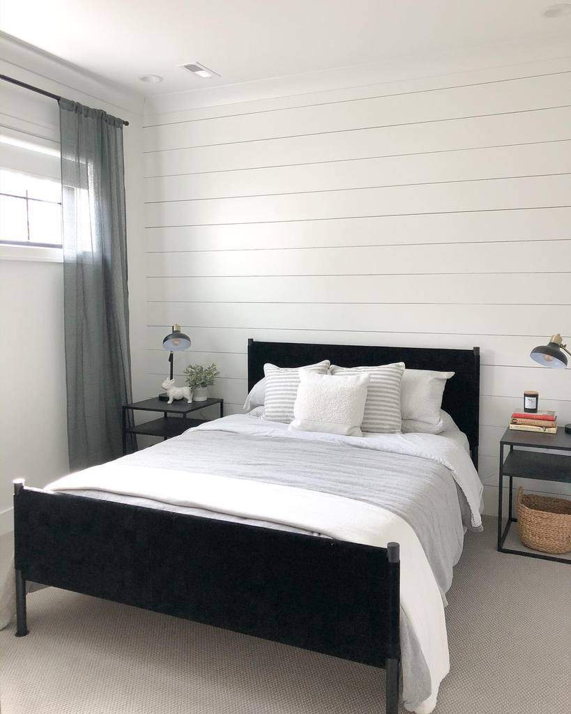 white shiplap wall bedroom with black bed frame 