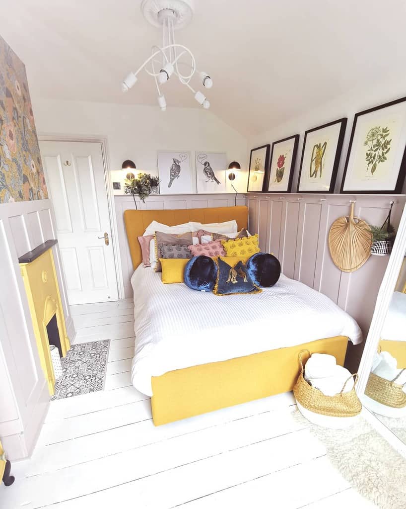 small bedroom white wall paneling yellow bed and fireplace 
