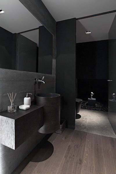 Black toilet with black wall tile background.  Light gray floor tiles.