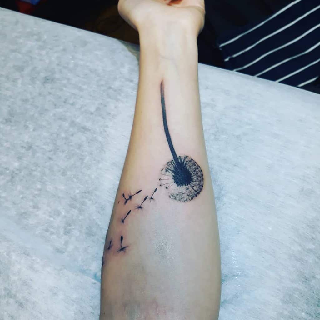 black dandelion arm tattoo