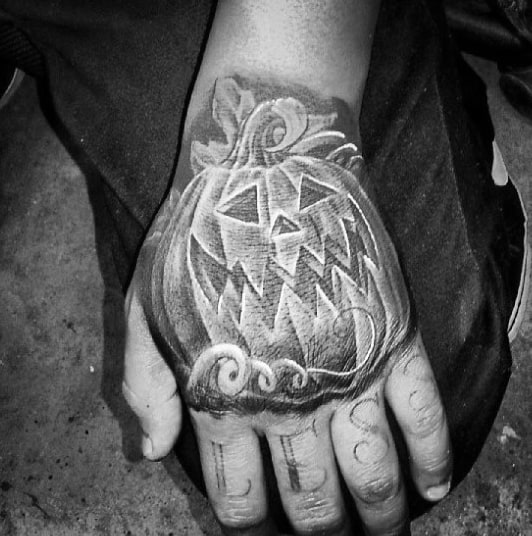 Black Ink Shaded Pumpkin Male Hand Tattoo