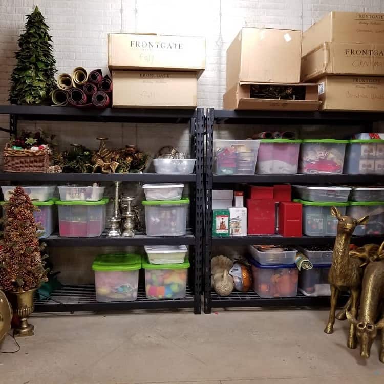 Basement storage shelves with labeled bins and boxes holding Christmas decorations and holiday items.