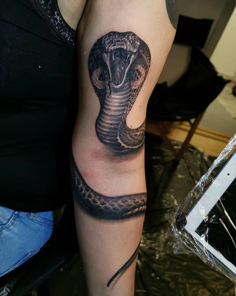 2. Black and Gray Upper Arm Snake Tattoos.