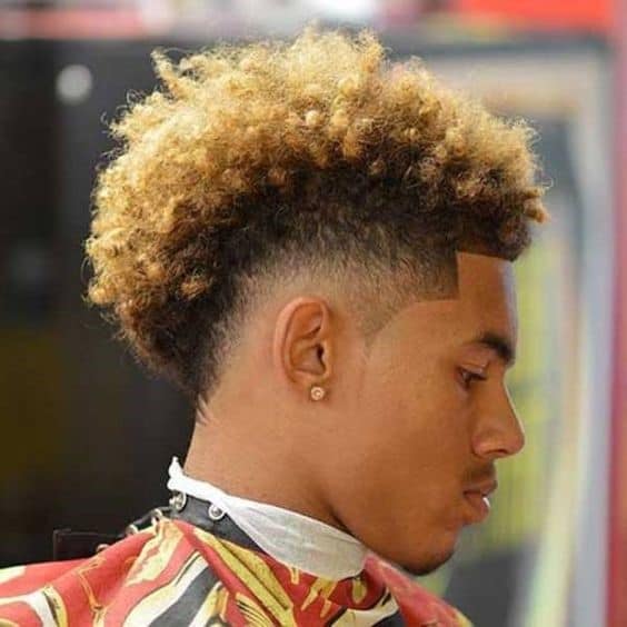 A frohawk haircut for black men with blonde hair on top and faded sides
