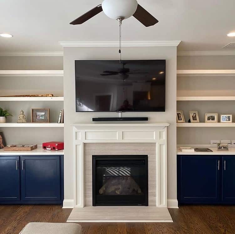 white fireplace surround blue cabinets and shelves wall mounted tv 