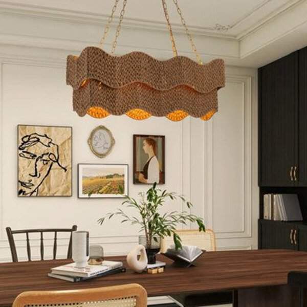 Boho dining room featuring bold statement lighting, including a wavy woven chandelier, art on the walls, and a cozy, minimalist table setting.