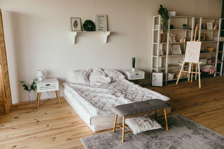 large boho bedroom white shelf unit hardwood flooring 