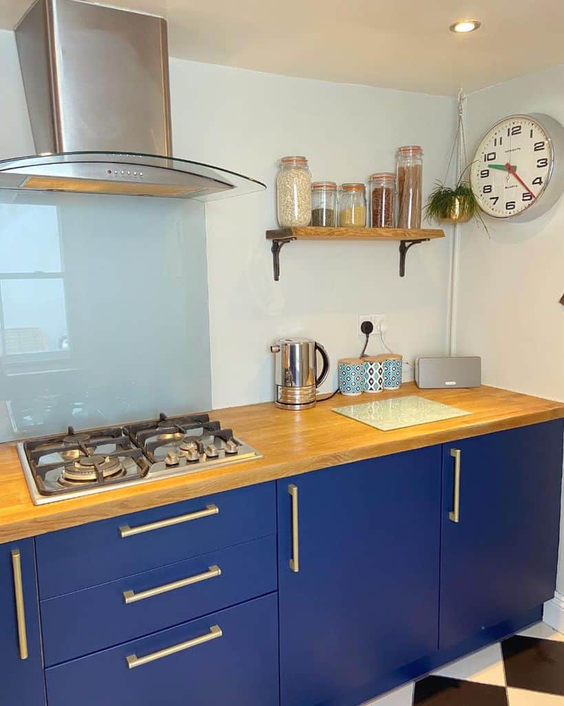 small kitchen with blue cabinets and wood countertop 
