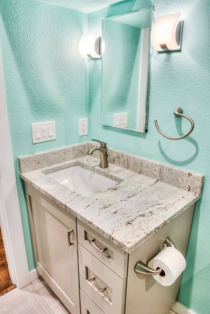 green painted bathroom with white granite countertop vanity 