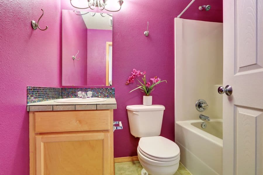 bright purple bathroom with shower/bath combo 