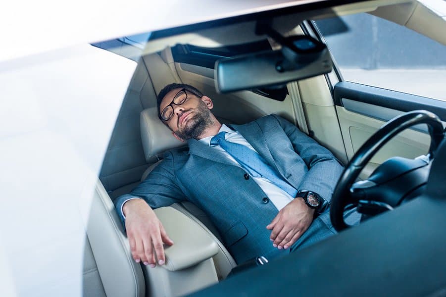 businessman in eyeglasses sleeping in car