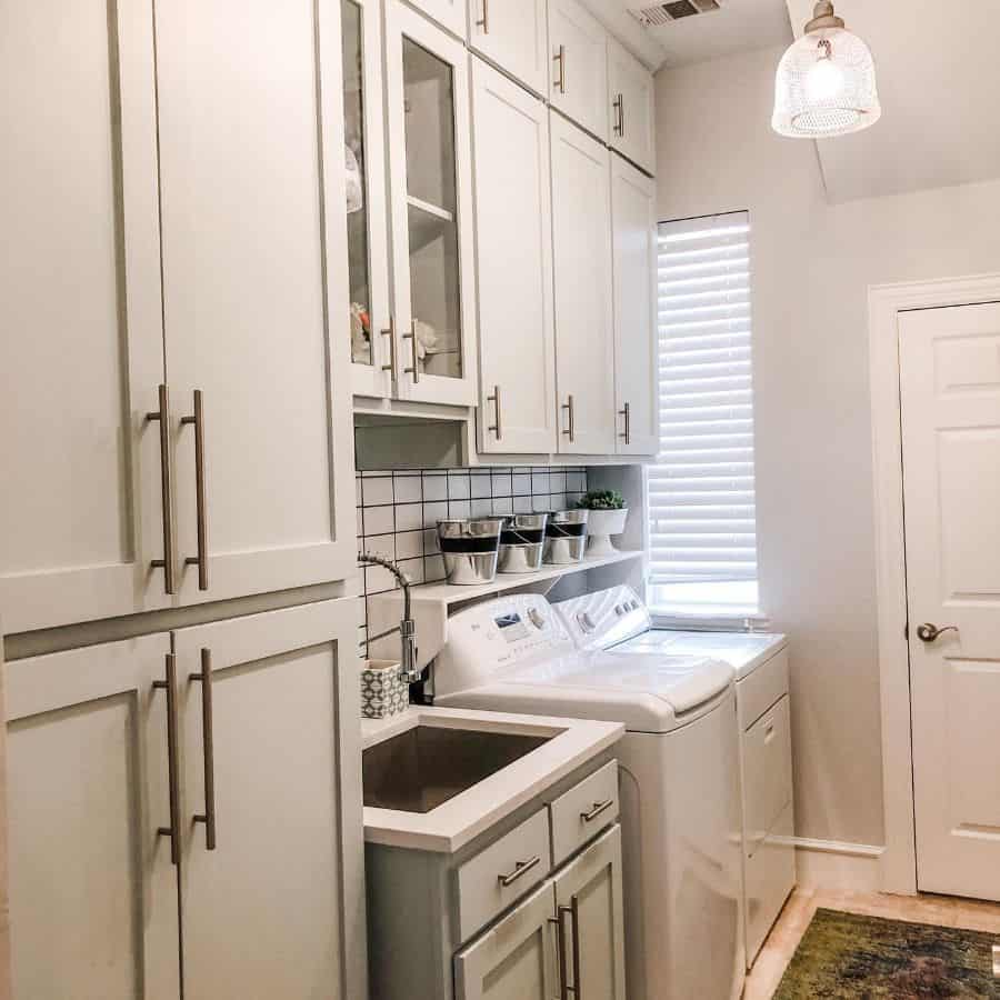 white cabinet laundry room side by side washer and dryer