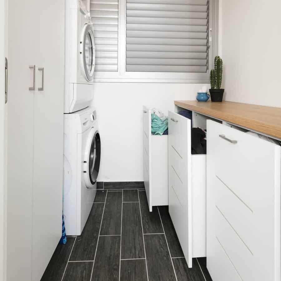 white cabinet laundry room vertical washer and dryer black floor tiles