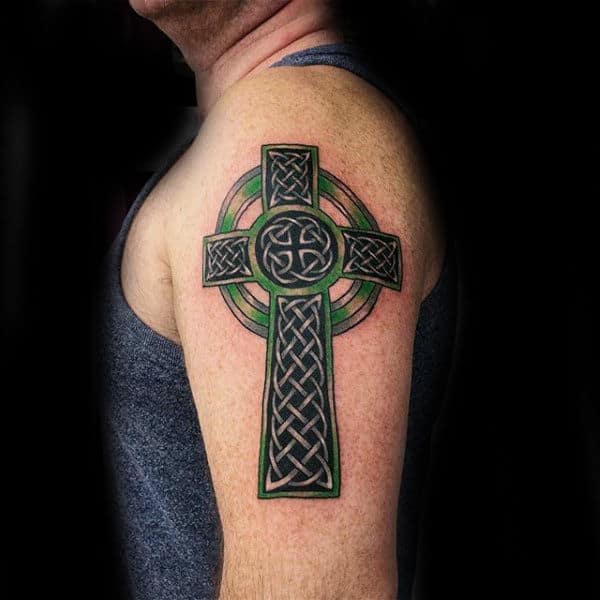 Celtic Cross Tattoo With Black And Green Ink On Males Upper Arm