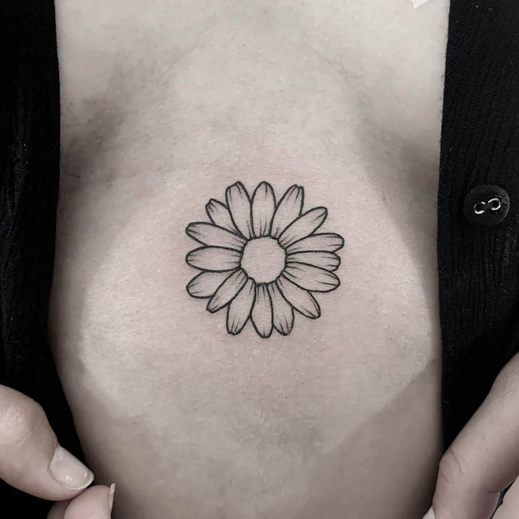 Female chest tattoo black and grey fine line daisy