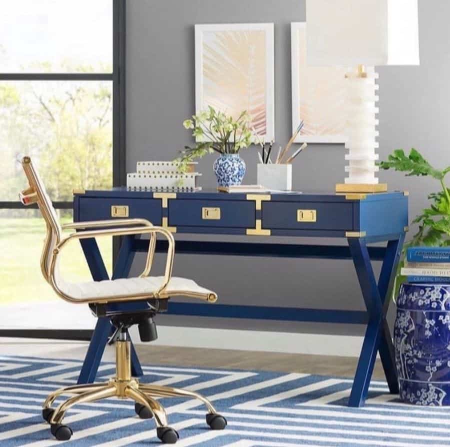 blue desk with gold accents gold office chair framed wall art china vases 