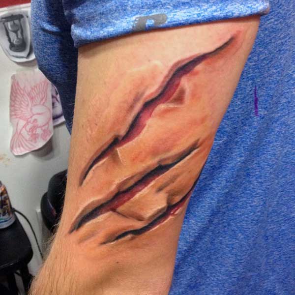 Claw Ripping Skin Tattoo On Mans Back Of Arm