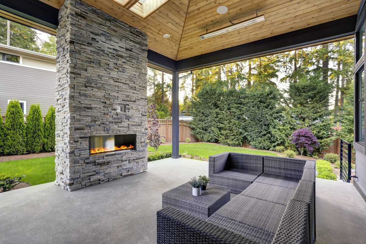 modern concrete patio stone fireplace wicker furniture 