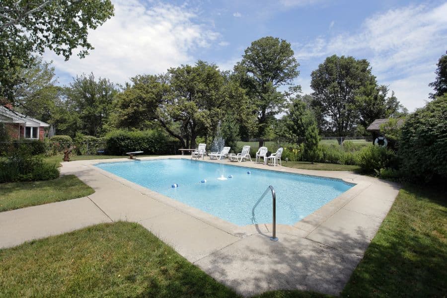 large backyard pool with concrete patio 