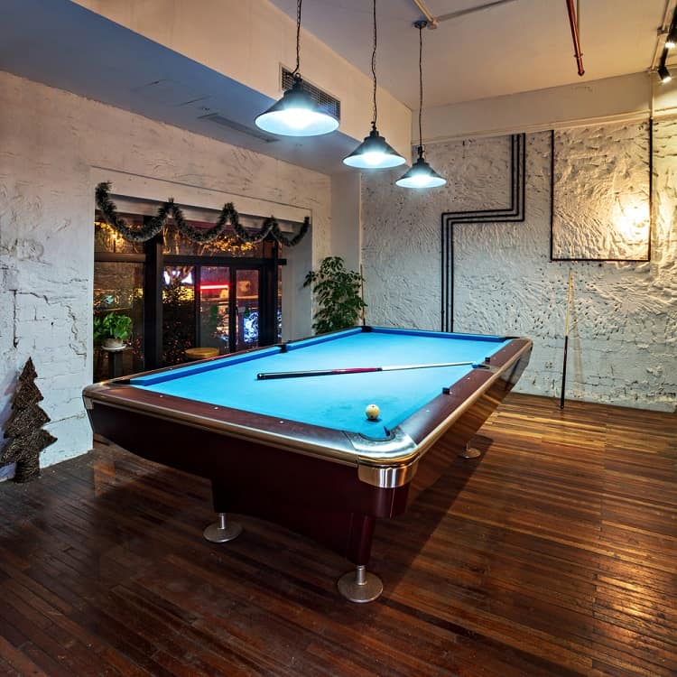 textured white wall games room billiard table pendant lighting hardwood floors