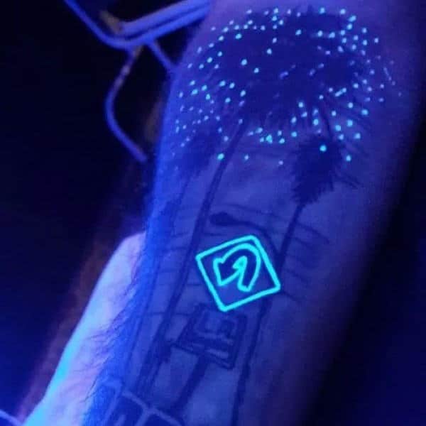 Cool Glow In The Dark Tattoo Of Glowing Tree And U Turn Sign On Mans Arm