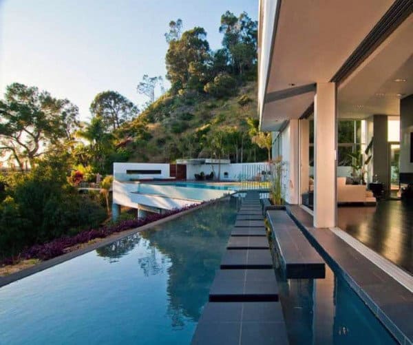 Cool Home Swimming Pool With Black Stepping Stones Above Surface Of Water