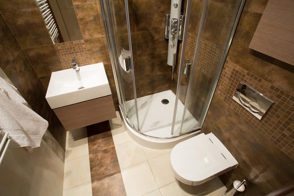 brown tile bathroom with corner shower 