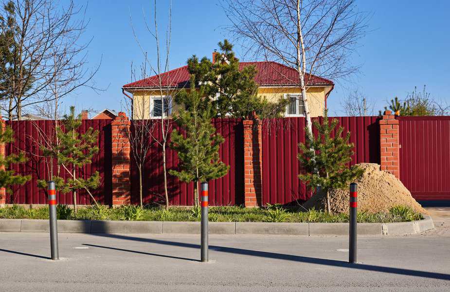 red metal corrugated fence with brick pillars