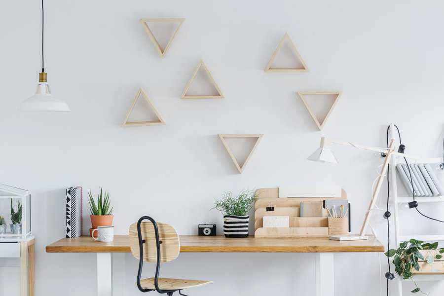 white scandi interior with wooden desk, triangle shelves and plants