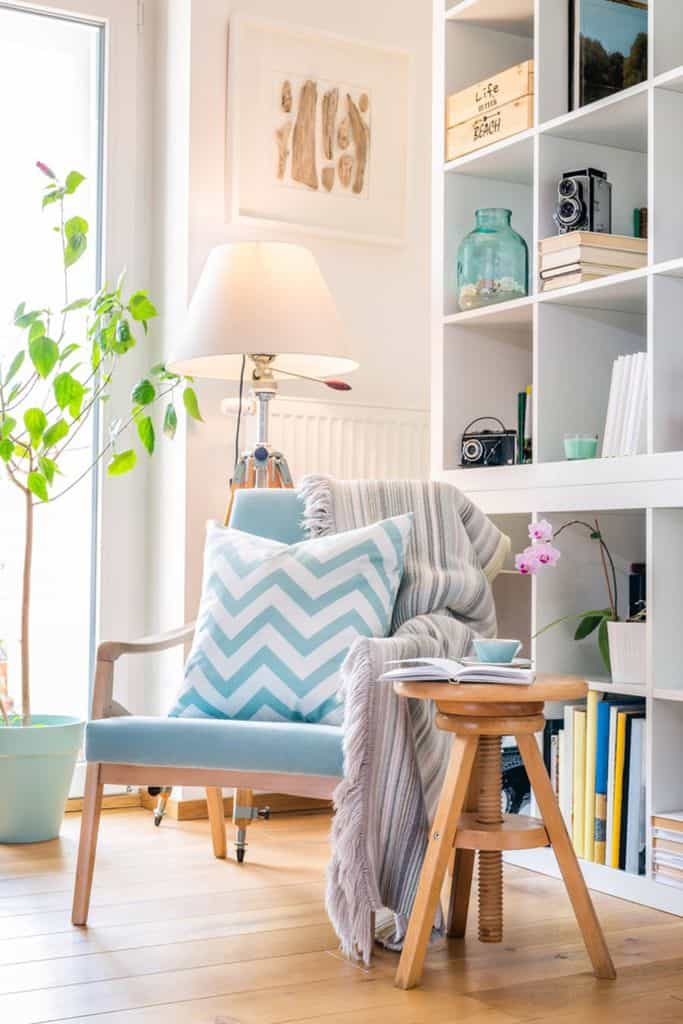 comfy blue accent chair next to bookshelf 