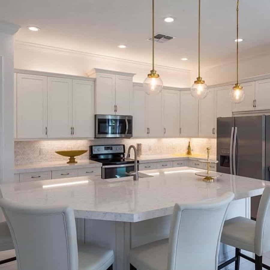 large white cabinet kitchen with curved island and pendant ceiling lights 