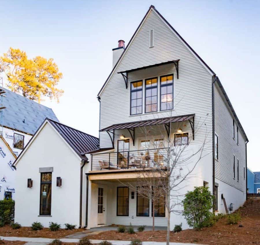three story white exterior farmhouse with black trim accents 