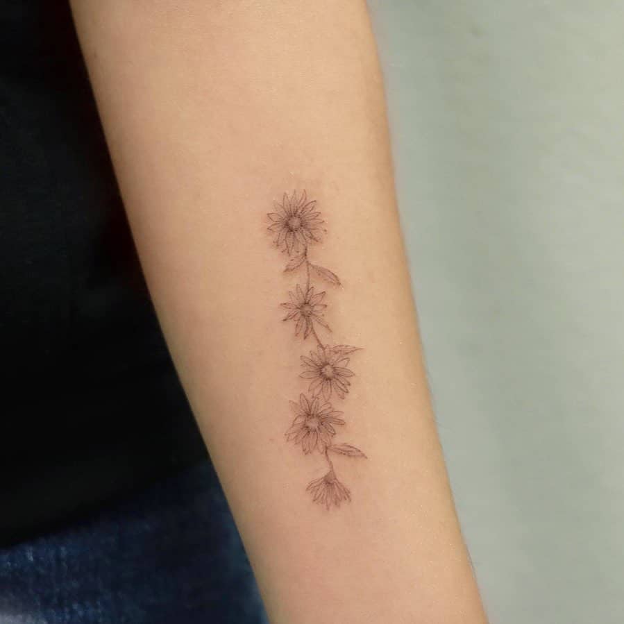 Forearm tattoo black and grey fine line delicate daisy chain