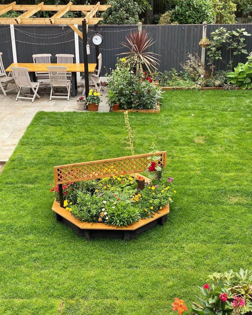 small garden bed middle of grass wood table and chairs gazebo 