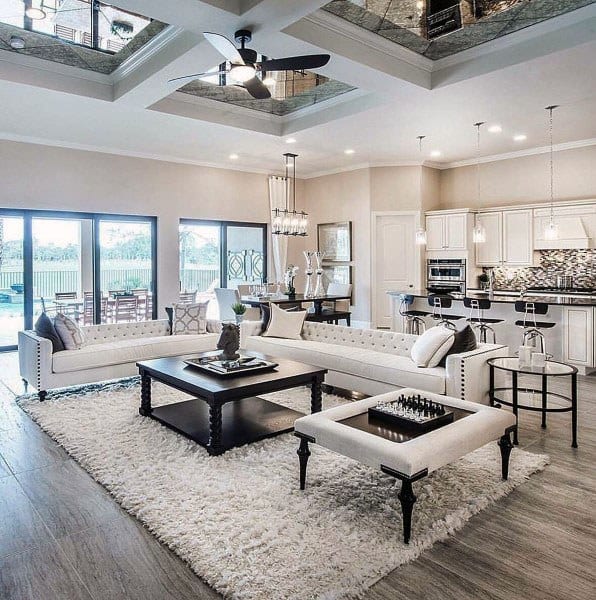 luxurious living room kitchen white rug white sofas black coffee table ceiling fan breakfast bar