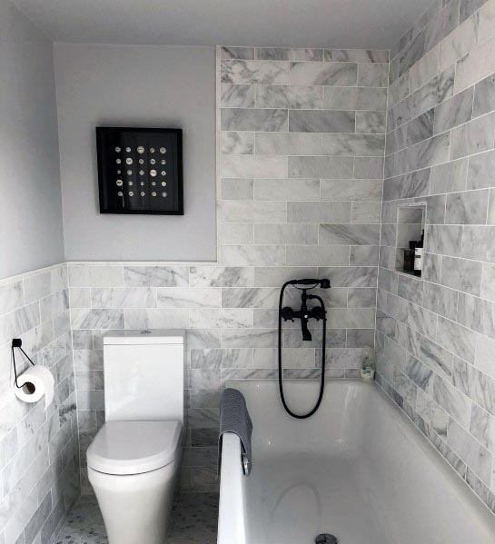 toilet and bath with grey tile walls