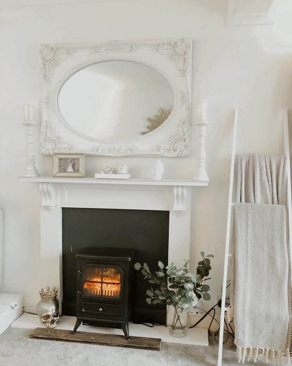 all white faux fireplace surround with electric fireplace mirror 