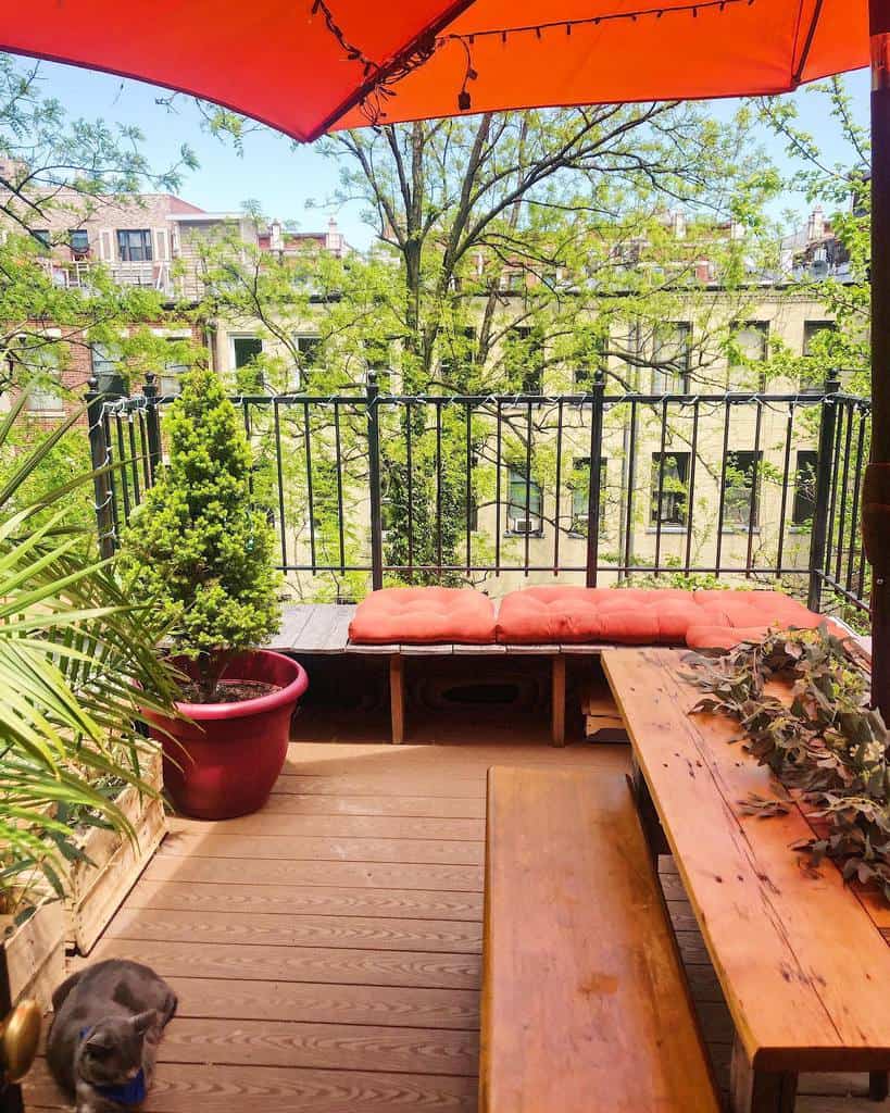 balcony patio with wood bench and umbrella shade