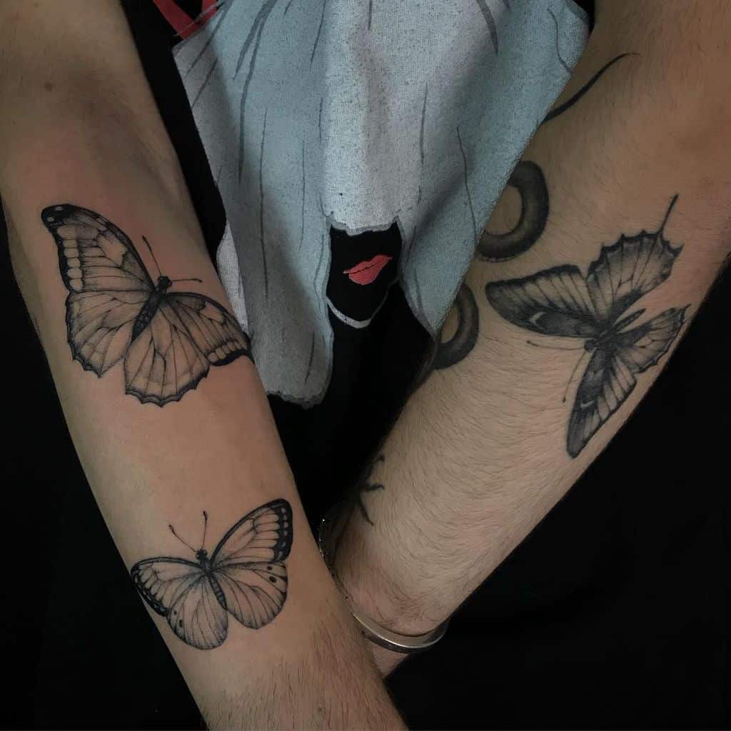 medium-sized black and grey tattoos on man's forearms of three realistic butterflies