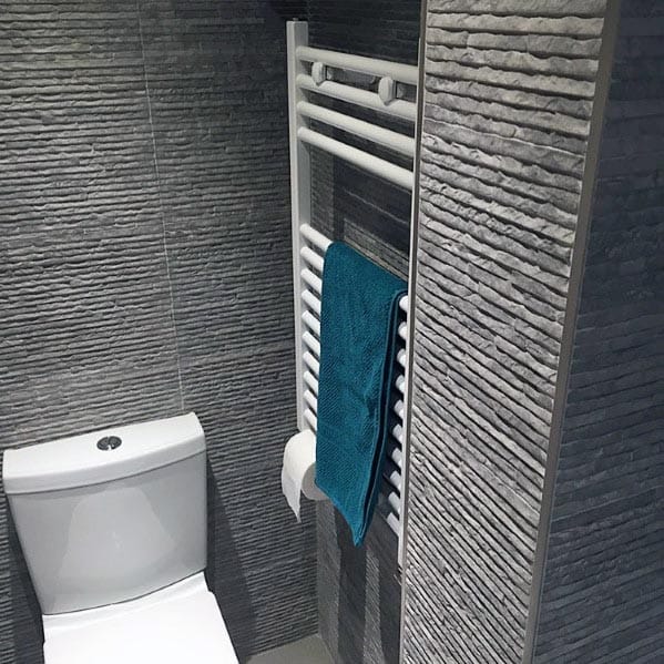textured gray tile bathroom with white toilet