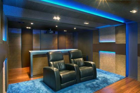 small home theater with blue led lighting and black recliners 