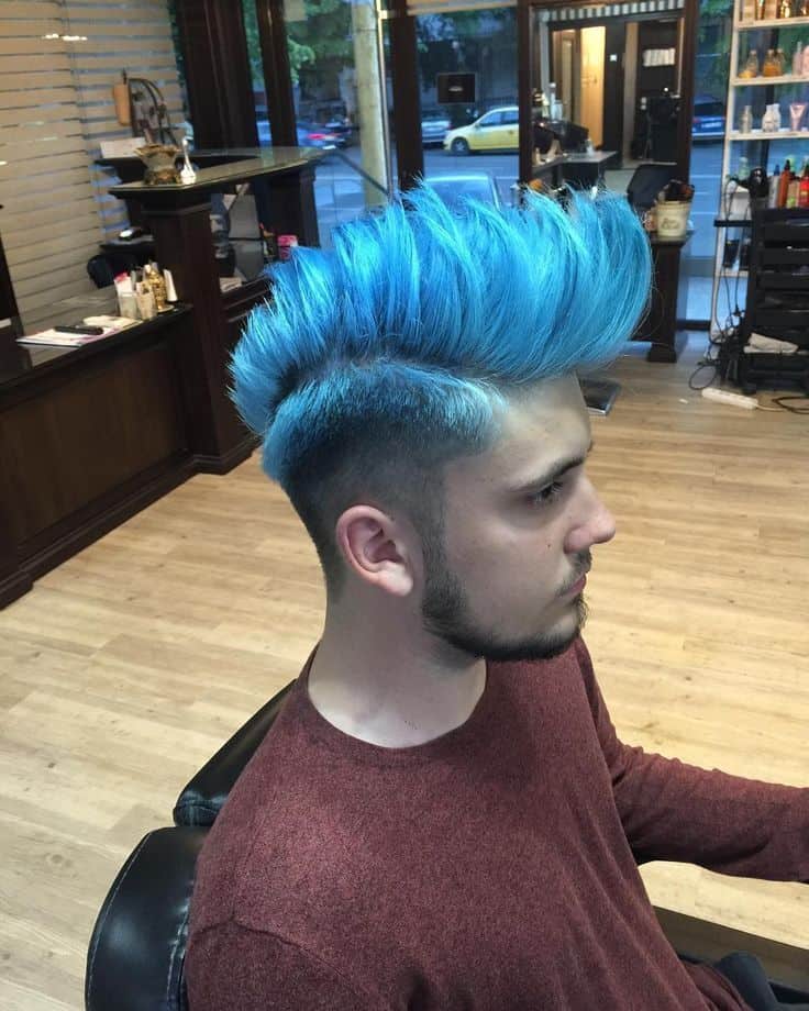 A cyberpunk Mohawk with long hair on top shaded blue and faded sides with hue of black