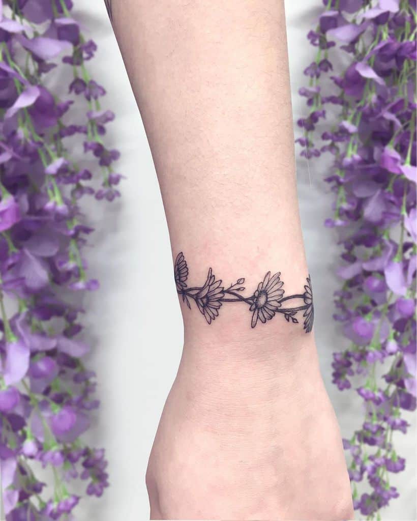 Wrist wrap around tattoo black and grey fine line daisy chain