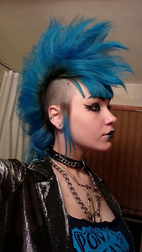 extravagant punk Mohawk styled to look like a cock and shaded blue. The sides are faded and remain black