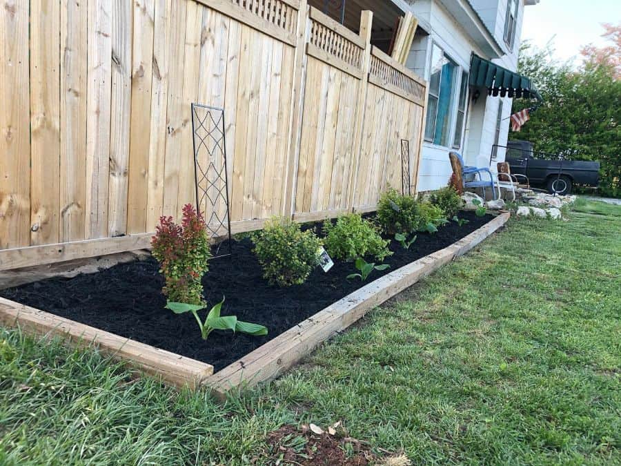 wood fence newly planted garden bed front yard