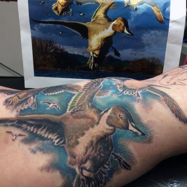 Flying Ducks Over Blue Sky Tattoo On Guy