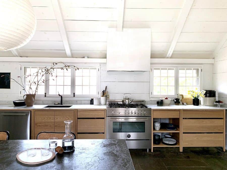 large country style kitchen with wood cabinets and white shiplap walls 