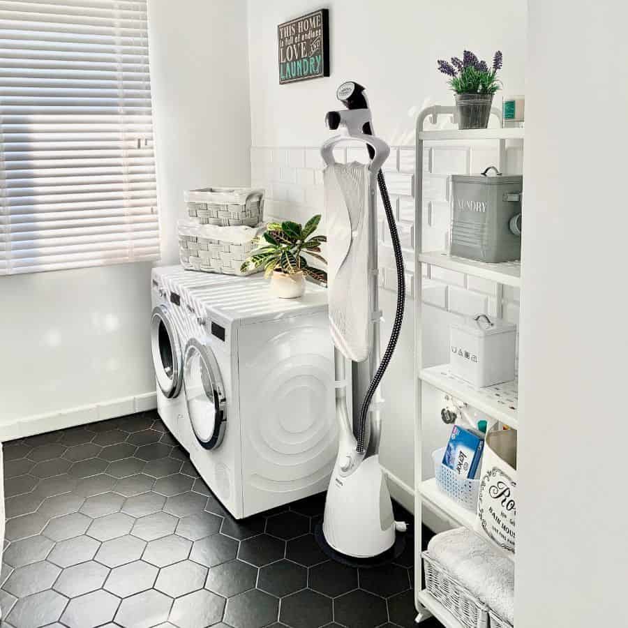 free standing laundry room washer and dryer black tile floor