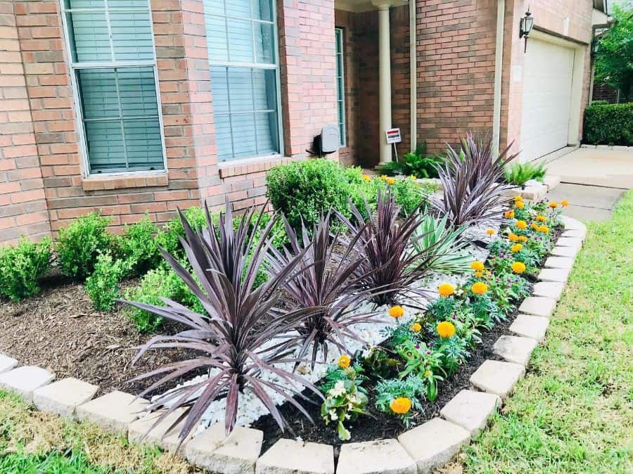 front yard flower bed surrounded by bricks